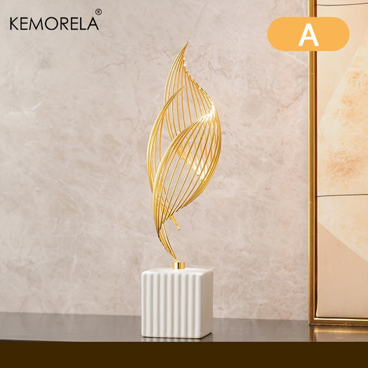 Decorative gold leaf sculpture on a white base against a beige wall with KEMORELA branding.