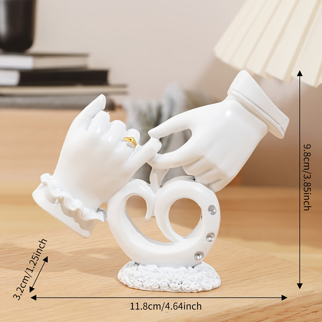 Decorative white sculpture of hands holding a heart with measurements on a wooden surface.