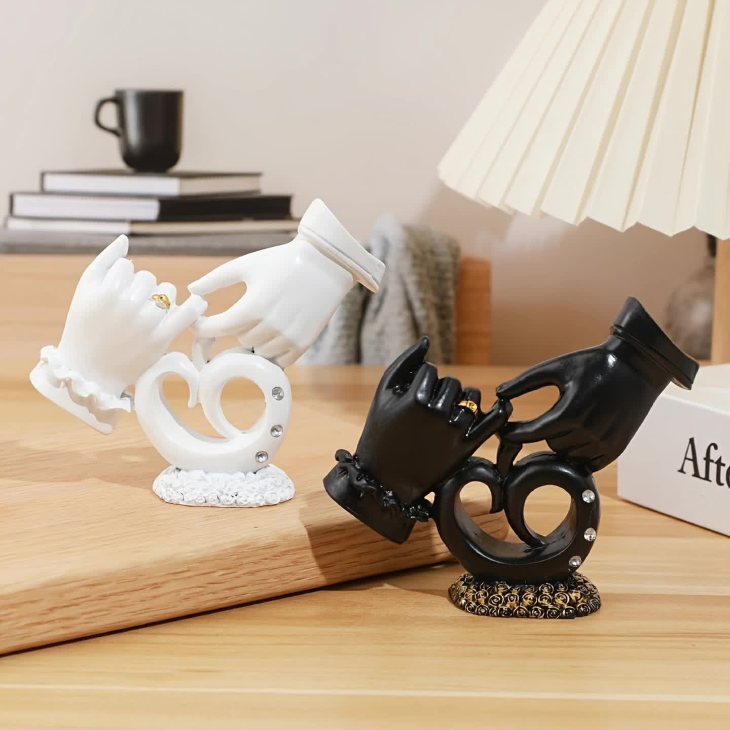 Black and white decorative hand sculptures on a wooden surface with a blurred background