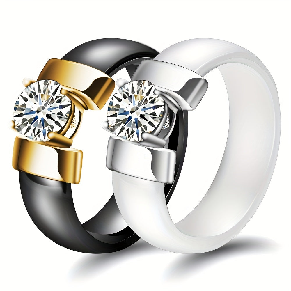 Two rings in gold, silver, and black with clear gemstones on a white background