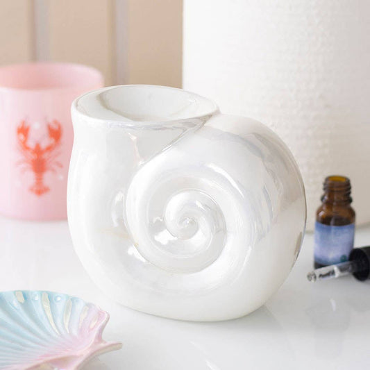 White ceramic snail-shaped diffuser on a white surface with a blurred background