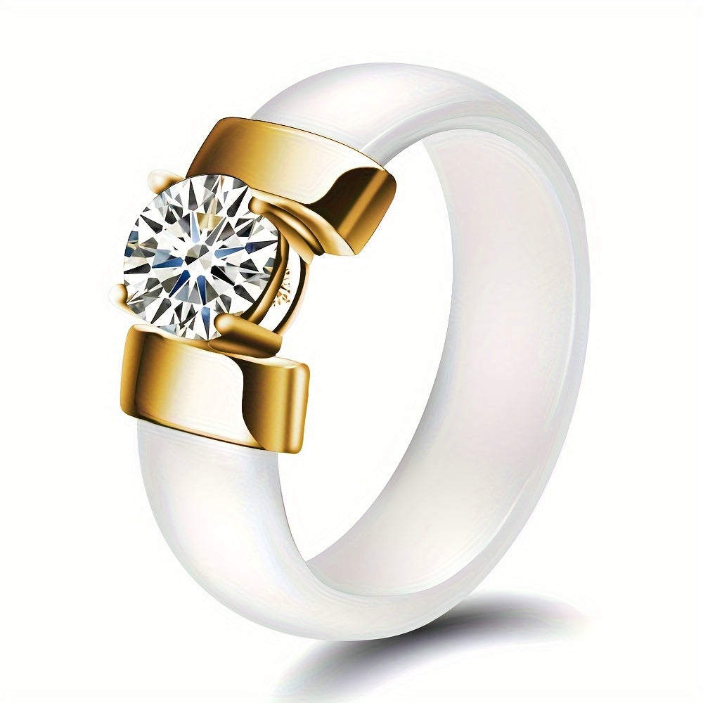 Ring with gold band and clear gemstone on a white background