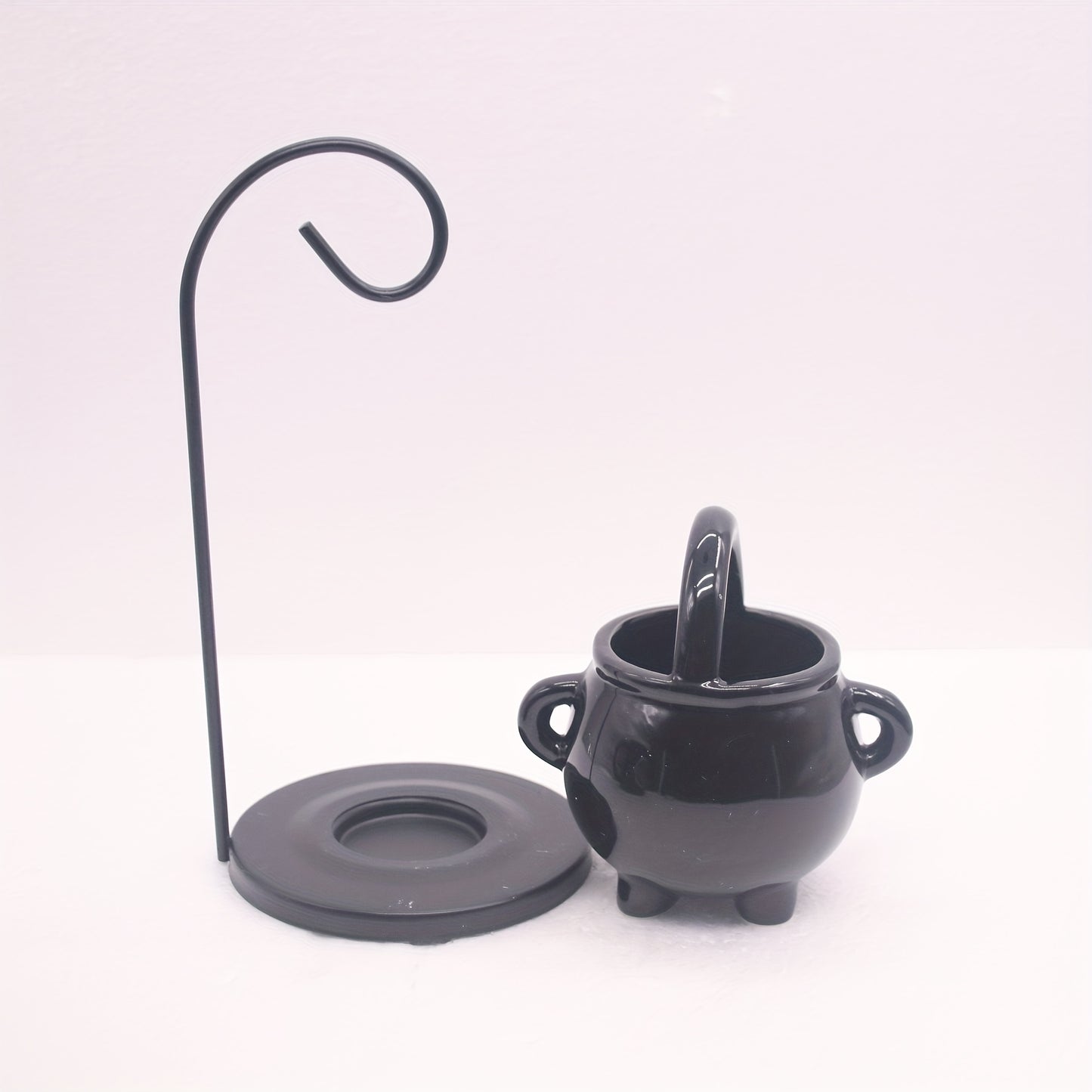 Black ceramic cauldron with a stand on a white background