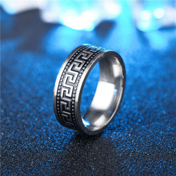 Silver ring with intricate design on a blue textured background